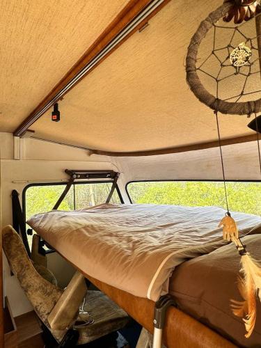a bed in the back of a camper van at Pauls caravan for 4 - See the horses from your bed in Barão de São João