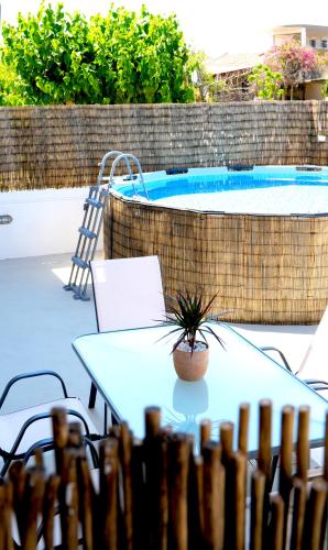 a table and chairs next to a swimming pool at IKARUS apartment with courtyard & pool in Chania in Stérnai