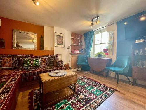 a living room with a couch and a table and a tub at Retro Waves Retreat – A Stylish and Vibrant Getaway in Central Brighton in Brighton & Hove