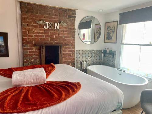 a bedroom with a large bed and a bath tub at Retro Waves Retreat – A Stylish and Vibrant Getaway in Central Brighton in Brighton & Hove