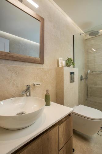 a bathroom with a white sink and a toilet at Vasi Luxury Apartment in Rhodes Town