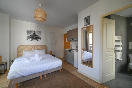 une chambre avec un lit blanc et une salle de bain dans l'établissement Lovely parisien apartment (opera 3), à Paris
