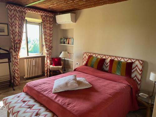 um quarto com uma cama grande com um cobertor vermelho em Country House Pais - Relax in jacuzzi tra i vigneti em Quargnento