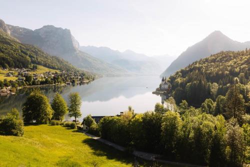 a view of a lake with mountains in the background at MONDI Hotel am Grundlsee in Grundlsee