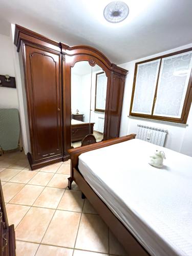 a bedroom with a bed and a cabinet and a window at Malpensa Retreat in Ferno