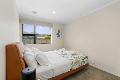 a bedroom with a bed and a window at Central Lower Hutt Gem - Steps to Queensgate & Station in Lower Hutt