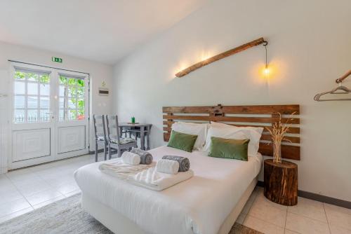 a bedroom with a large white bed and a table at Fountain Retreat I Pool, Jacuzzi & Sports Escape in Viana do Castelo