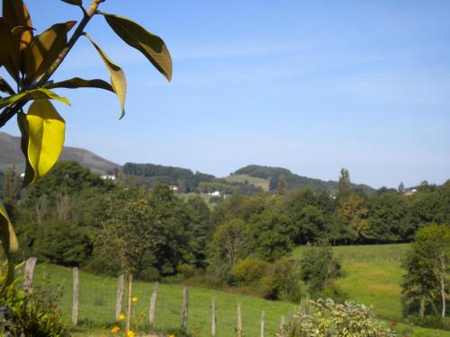 a field with a fence and trees in the background at Gite de charme 3* in Saint-Esteben