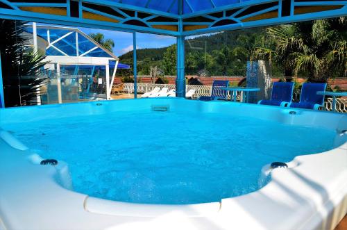 a swimming pool with blue water in the middle at Pousada das Videiras boutique in Monte Verde