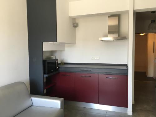 a kitchen with red cabinets and a microwave at En Aparté in Porto-Vecchio