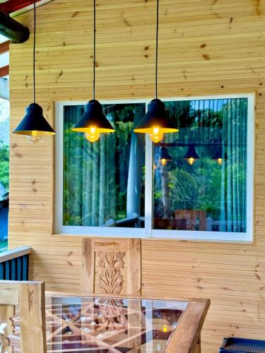 a dining room with a glass table and lights at Guest Inn Avendra in Ella