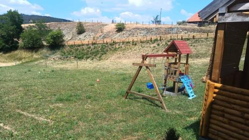 a playground in a yard with a swing set at Koliba kod Vukašina in Kremna