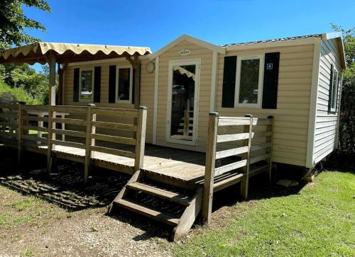 a tiny house with a porch and a wooden ramp at Camping 3 étoiles - efaicg in Auxonne