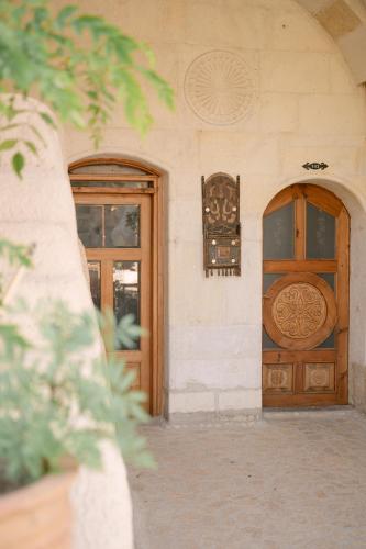 a building with two wooden doors on the side of it at Potamia Cave Suites in Ortahisar