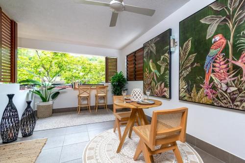 a living room with a table and chairs at Chic Couples Retreat in Port Douglas