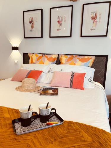 - un lit avec un plateau avec deux tasses dans l'établissement La Glycine B&B, à Sainte-Colombe