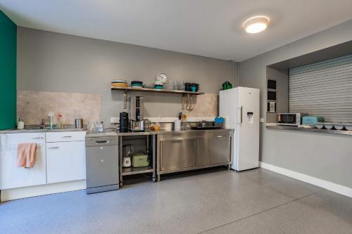 a kitchen with stainless steel appliances and a white refrigerator at Bright Ensuite on Lower Baggot in Dublin