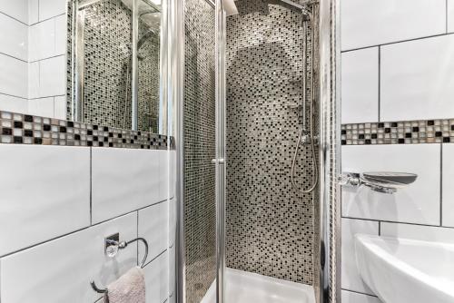 a shower with a glass door in a bathroom at Stylish 4 bed in Bracknell with Games Room in Bracknell