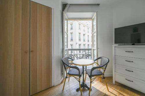 Cette chambre dispose d'une petite table et de chaises. dans l'établissement Opéra 2, à Paris