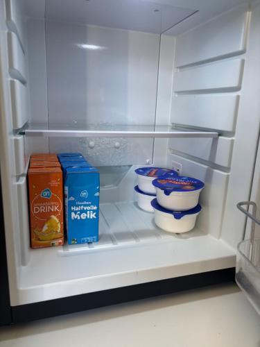 un réfrigérateur ouvert contenant de la nourriture et du lait dans l'établissement Bed & Breakfast Waterpoort - incl licht ontbijt en parking, à Sneek