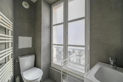 une salle de bain avec toilettes, lavabo et fenêtre dans l'établissement Opéra 2, à Paris