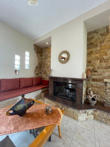 a living room with a fireplace and a red couch at Villa Geomare in Apolakkiá