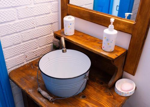 a bucket sitting on a wooden shelf next to a mirror at La Lipoveni in Jurilovca