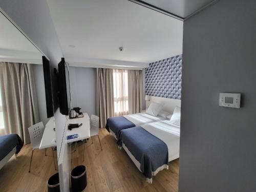 a hotel room with a bed and a television at Hotel Monte Rozas in Las Rozas de Madrid