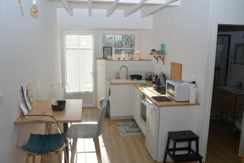 a kitchen with a counter and a table with a microwave at La Dunette, un nid douillet entre mer et campagne in Carolles
