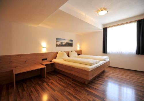a bedroom with a bed and a large window at Apart am Brunnen in Ried im Oberinntal