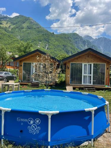 a pool in front of a house with mountains at Thethi Mountain Villas in Theth