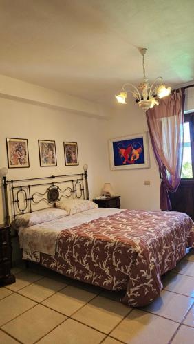 a bedroom with a bed and a chandelier at Casa Terranova in Ustica
