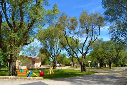 a park with a playground with trees and a house at Green Park Hotel & Residence in Bagnara Calabra