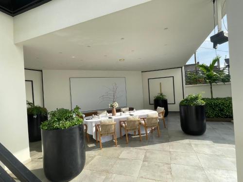 a dining room with a table and chairs and plants at Kemadjou Boutique Stay in Yaoundé