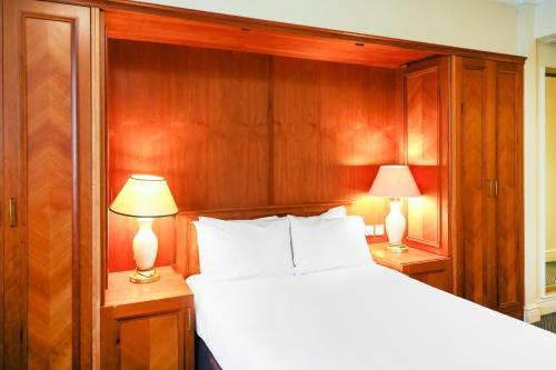 a bedroom with a white bed and two lamps at OYO Tong Park Hotel in Bradford