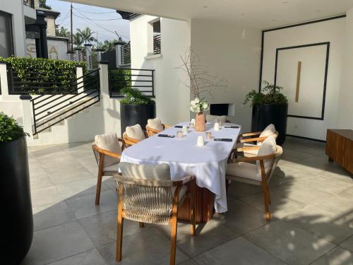 a table with chairs and a white table cloth at Kemadjou Boutique Stay in Yaoundé