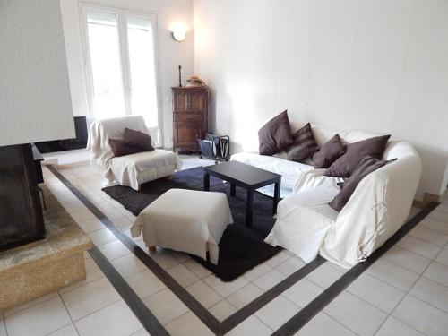 a living room with two white couches and a table at Maison de vacances avec piscine à 20min des plages in Castelnau-le-Lez