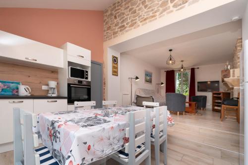 d'une cuisine et d'un salon avec une table et une nappe. dans l'établissement Au Pied Des Chênes, à Crach
