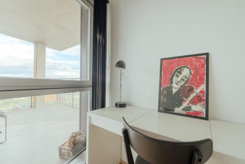 a desk with a chair in a room with a window at 2 BR Ocean and City View Apartment in Tórshavn