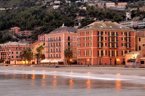 un gruppo di edifici vicino a uno specchio d'acqua di Hotel Residence Baiadelsole a Laigueglia