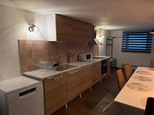 a kitchen with wooden cabinets and a table with a tableablish at Le Foyer Ardennais in Trois-Ponts
