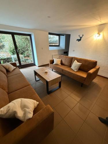 a living room with a couch and a coffee table at Le Foyer Ardennais in Trois-Ponts