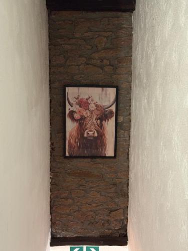 a painting of a cow hanging on a wall at Le Foyer Ardennais in Trois-Ponts