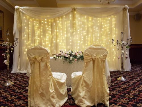 a wedding altar with two gowns in a room with lights at Flagstaff Lodge in Newry