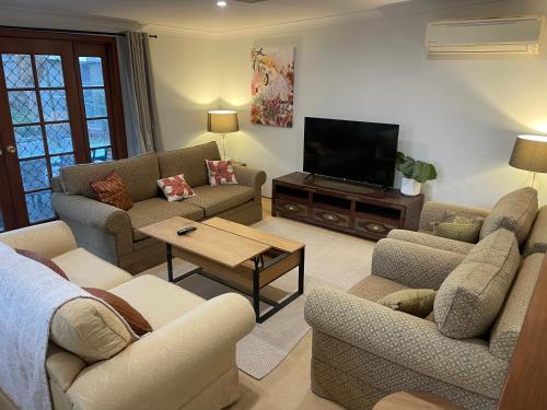 a living room with couches and a flat screen tv at Luxury Lake Front Living in Lake Albert