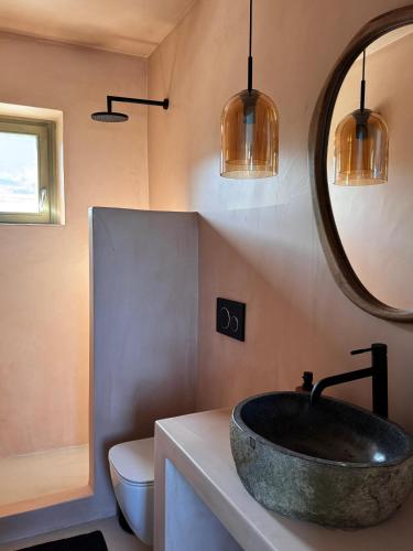 a bathroom with a stone sink and a mirror at Serifos Bliss in Rámos