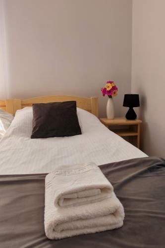a bed with two towels laying on top of it at Noclegi Pod Lyskami in Nowy Targ