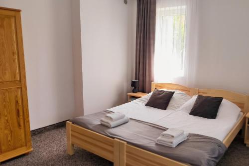 a bedroom with a bed with white sheets and a window at Noclegi Pod Lyskami in Nowy Targ