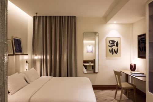 a hotel room with a white bed and a desk at A for Athens in Athens