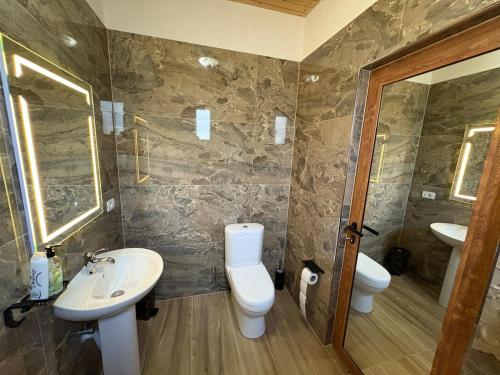 a bathroom with a toilet and a sink at Shtegu I Gjelber- Wood Rooms 